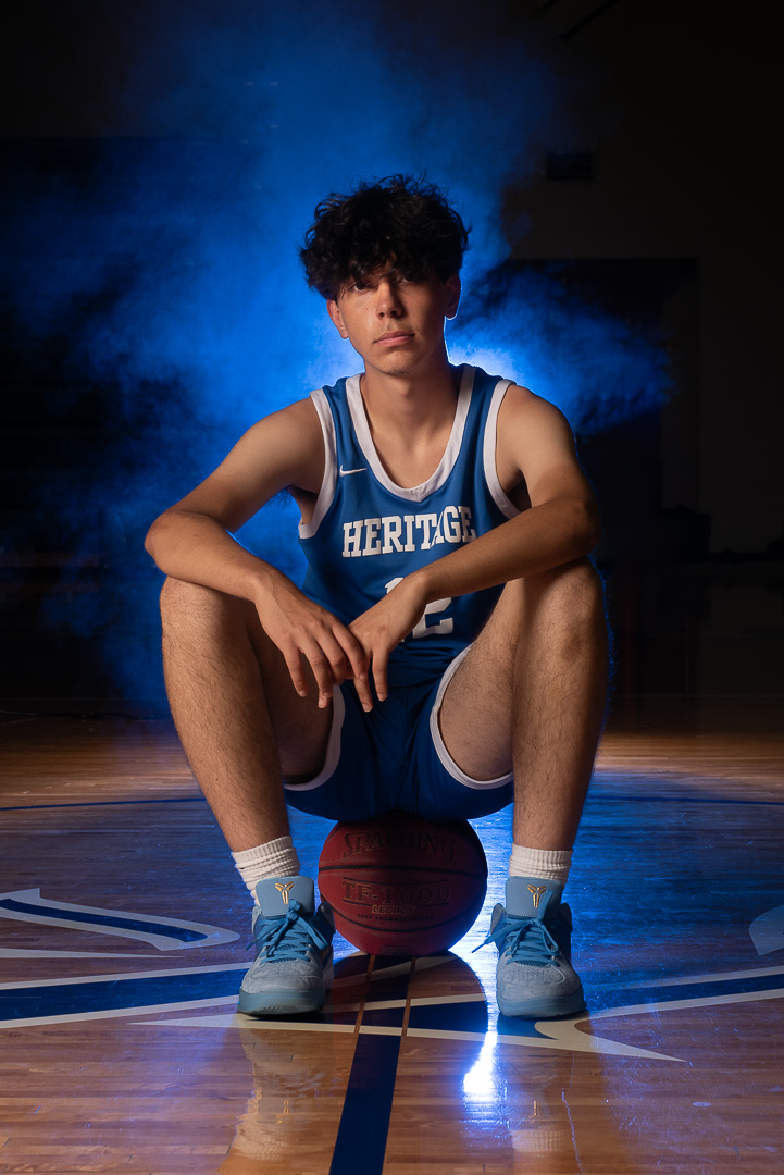 High school basketball athlete portrait of boy sitting on basketball, Maple Grove MN