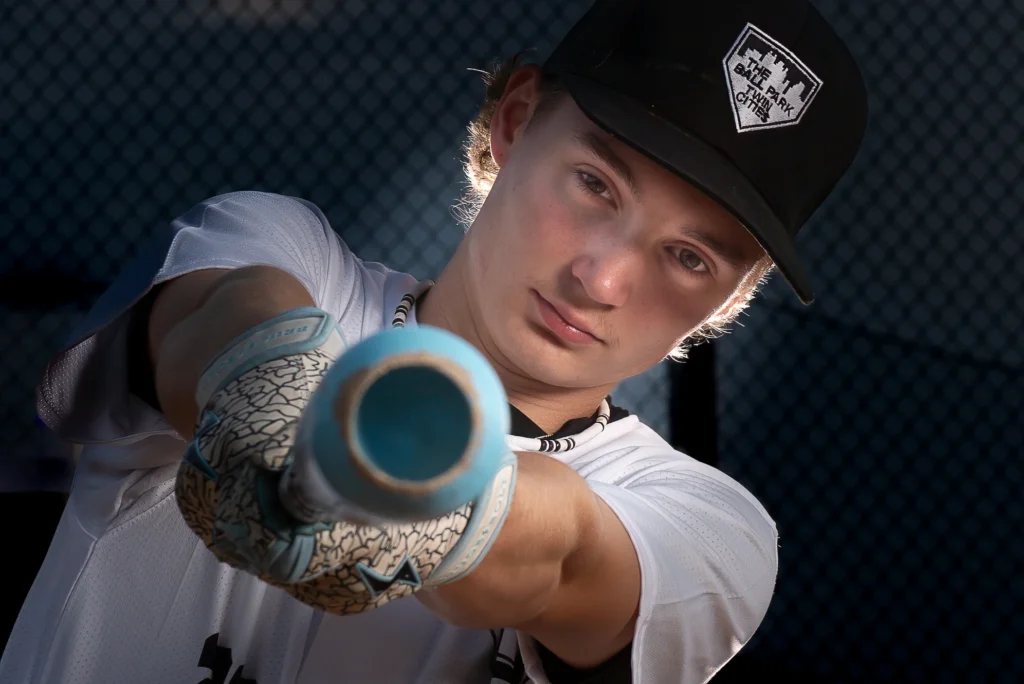 High school athlete posed in dramatic lighting for a sports portrait