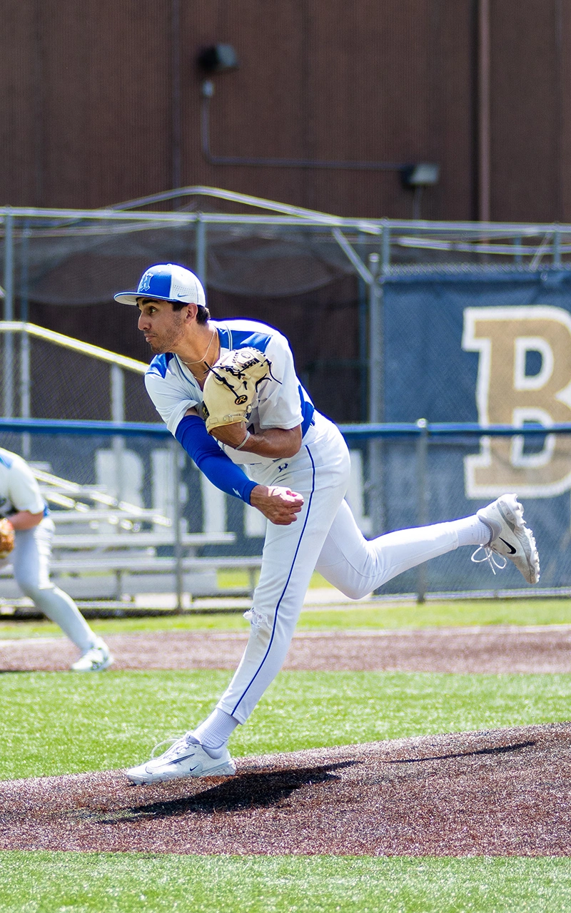 High school baseball pitcher follows through on delivery during a Minnesota game day