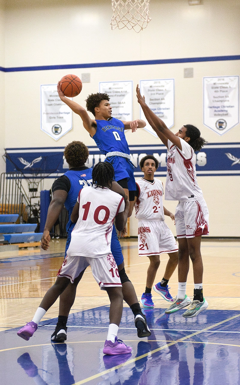 Heritage Eagles guard rises above defenders to score during a Minnesota high school basketball game
