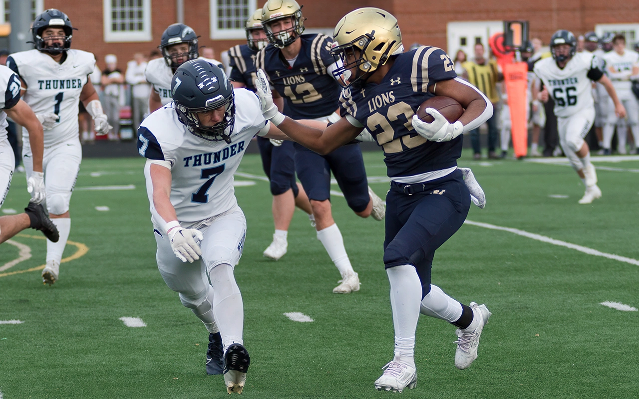 Lions high school running back delivers a stiff arm while breaking free during a Minnesota football game