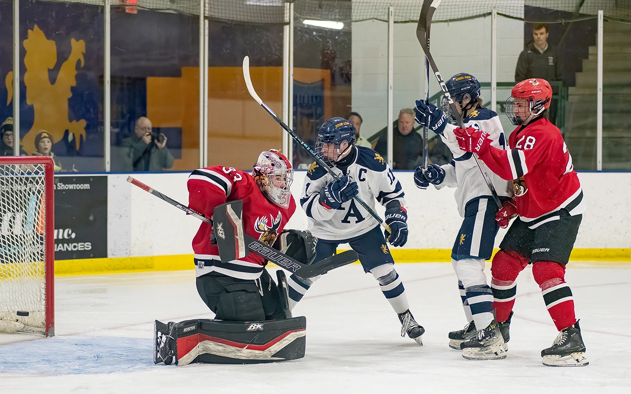 High school hockey players battle in front of the crease during a Minnesota game day