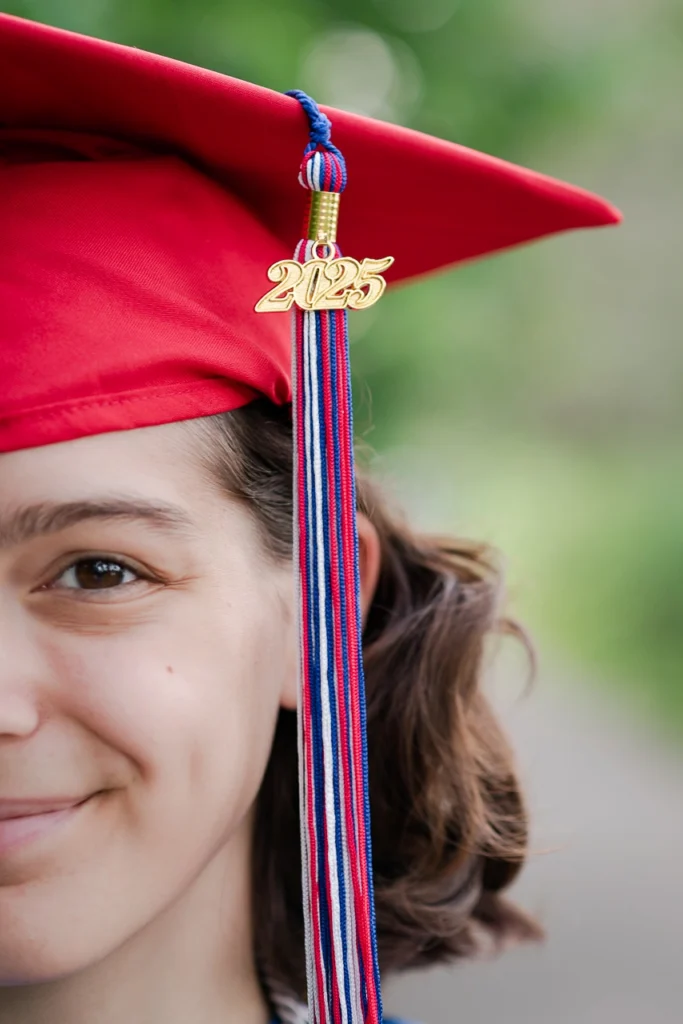 Creative close-up senior portrait with Class of 2025 graduation cap and tassel — Twin Cities senior photographer