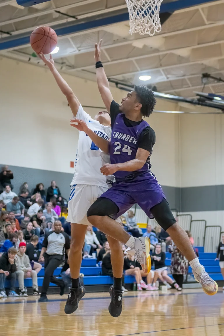 High school basketball player drives to the basket for a layup against a defender during a Minnesota game