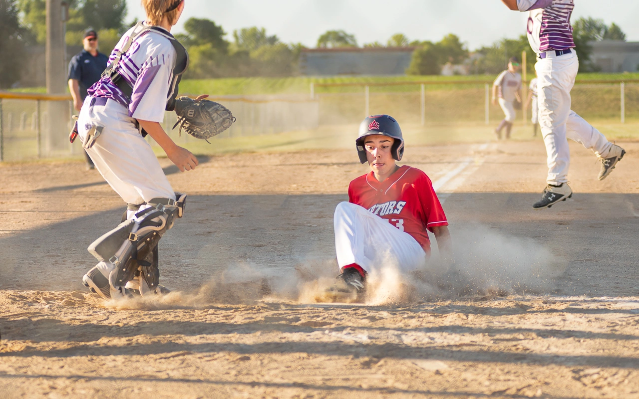 Travel baseball player slides into home plate during Minnesota tournament game
