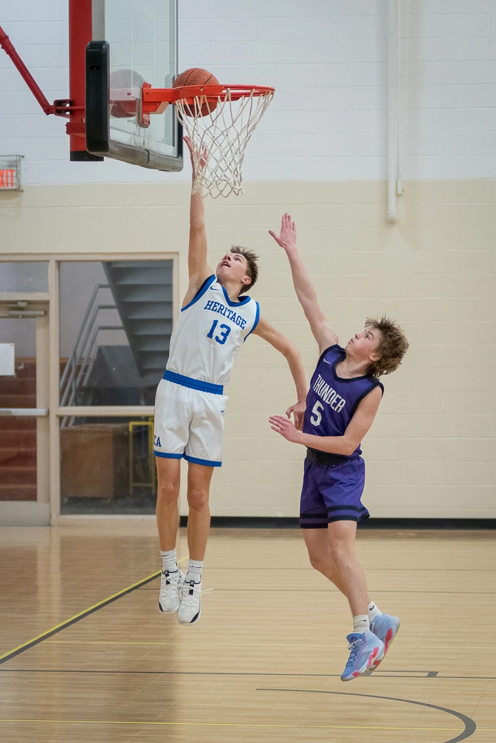 Heritage Christian basketball player goes up strong for a dunk attempt against a Thunder defender during a Minnesota game day